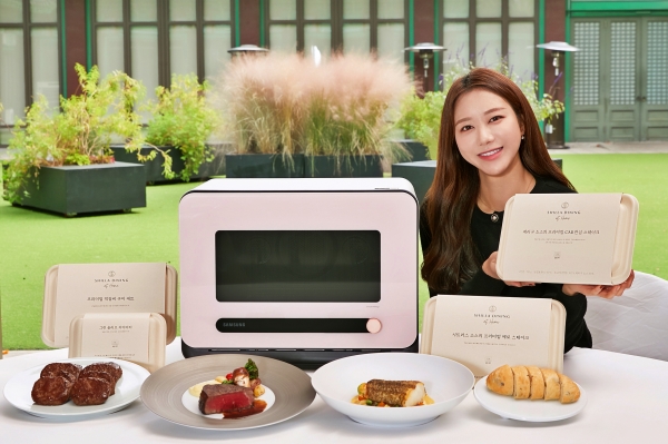 삼성전자 모델이 서울신라호텔 영빈관 앞에서 신개념 조리기기 '비스포크 큐커'와 전용 밀키트 '신라 다이닝 앳 홈' 3종을 소개하고 있다. (사진=삼성전자)