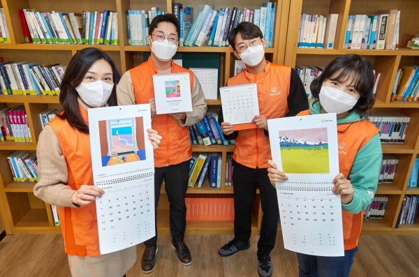 한화 점자달력 제작 21주년을 맞아 한화봉사단 임직원들이 점자달력을 소개하며 기념촬영 하고 있다. (사진=한화그룹)