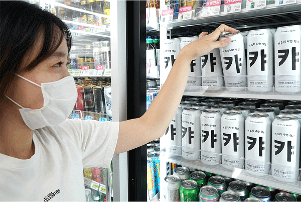 세븐일레븐 점포 냉장고에서 한 여성이 '캬 맥주'를 꺼내고 있다. (사진=코리아세븐) 