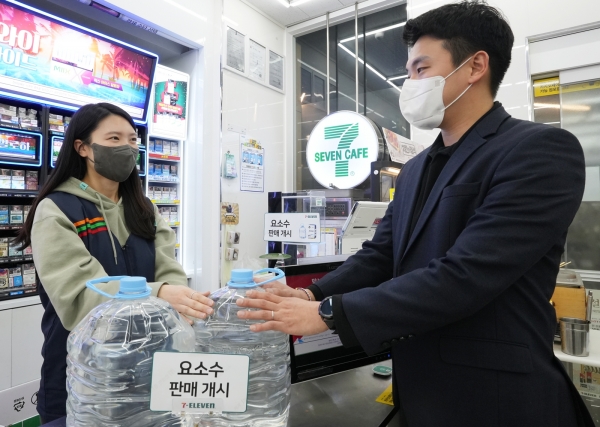 세븐일레븐 직원이 손님에게 요소수를 판매하고 있다 [사진=세븐일레븐]