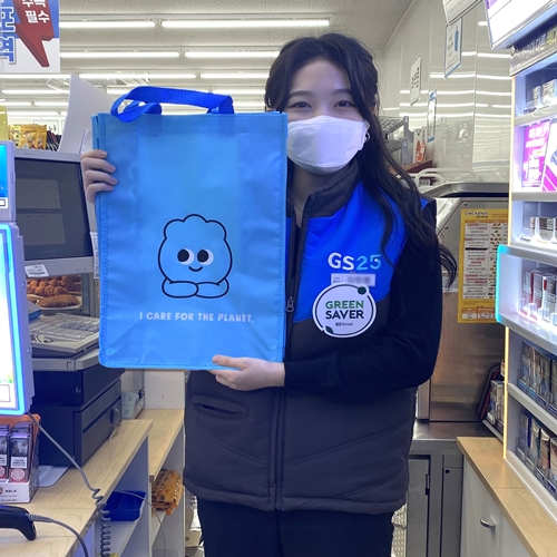 GS25 그린세이버 스토어매니저가 다회용 부직포 쇼핑백를 보여주고 있다 (사진=GS리테일)