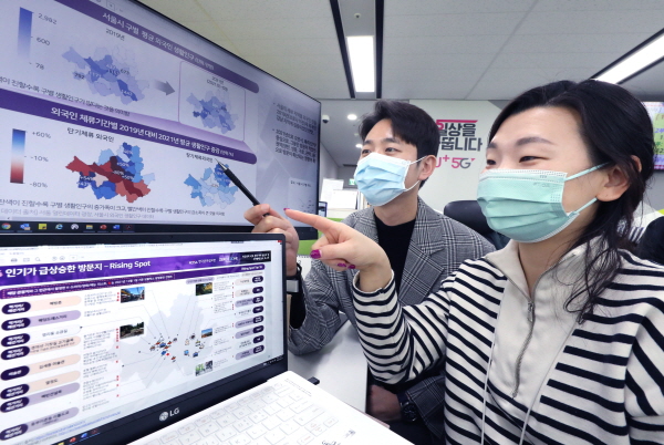 LG유플러스 직원들이 보고서에 수록된 서울시내 인기 방문지 지도를 살펴보고 있는 모습. (사진=LG유플러스)