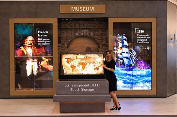 LG전자가 현지시간 10일부터 나흘간 스페인 바르셀로나에서 열리는 상업용 디스플레이 전시회 ISE 2022에 참가한다. LG전자 모델이 화면과 화면 너머 모습을 동시에 볼 수 있는 투명 올레드 터치 사이니지를 활용해 연출한 전시존을 소개하고 있다. (사진=LG전자)