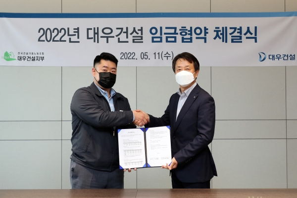 백정완 대우건설 대표이사(오른쪽)와 심상철 노동조합 위원장이 2022년 임금 인상안을 체결한 모습. (사진=대우건설)