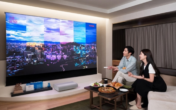 삼성전자 모델이 서울 광장동에 위치한 워커힐 호텔앤리조트 내 '시네마 스위트 with 삼성 더 프리미어' 객실에서 4K 고화질로 최대 130형의 초대형 화면을 감상할 수 있는 프리미엄 빔 프로젝터 '더 프리미어'와 '더 프리미어' 전용 롤러블 스크린을 체험하고 있는 모습. (사진=삼성전자)