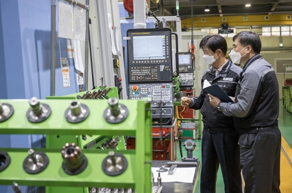 경기도 안산시에 위치한 금형생산기업 건우정공에서 박순황 회장(왼쪽)과 임선우 삼성전자 스마트공장지원센터 프로(오른쪽)가 CNC 가공설비를 살펴보고 있다. (사진=삼성전자)