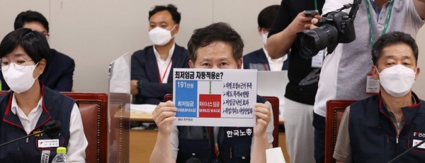 근로자위원인 정문주 한국노총 정책본부장이 지난 16일 오후 세종시 정부세종청사 최저임금위원회 회의실에서 열린 제4차 전원회의에서 최저임금 차등적용과 관련한 손팻말을 들어 보이고 있다. (사진=연합뉴스)
