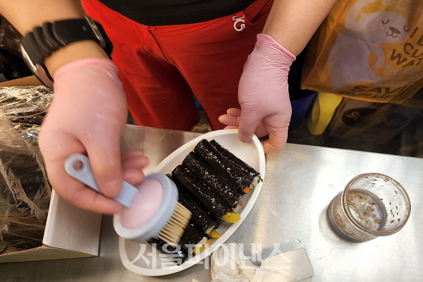 '나주댁 꼬꼬' 분식집 주인이 '마약김밥'에 참기름을 바르는 모습. (사진=김종현 기자)