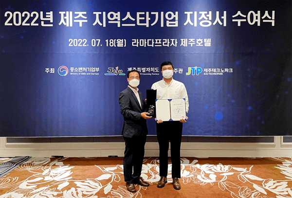 이성훈 김정문알로에 생명과학연구소 과장(오른쪽)이 지난 18일 제주시 탑동로 라마다프라자 제주호텔에서 양승열 제주특별자치도 미래전략과장으로부터 '2022년 제주 지역스타기업' 지정서를 건네받고 있다. (사진=김정문알로에) 