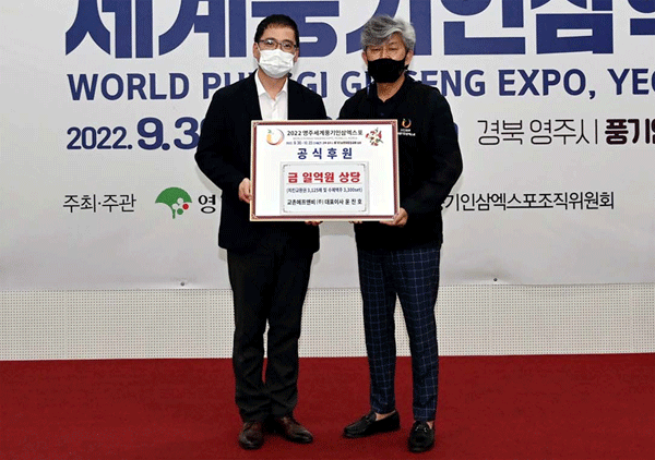 장규식 교촌에프앤비 마케팅실장(왼쪽)이 지난 7월 29일 경북 영주시 풍기읍행정복지센터에서 이창구 2022 영주세계풍기인삼엑스포조직위원회 부위원장한테 후원 물품을 건네고 있다. (사진=교촌에프앤비) 