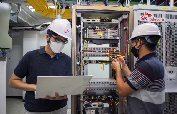 SK텔레콤과 SK브로드밴드 엔지니어가 유무선 통합 허브를 점검하는 모습. (사진=SK텔레콤)