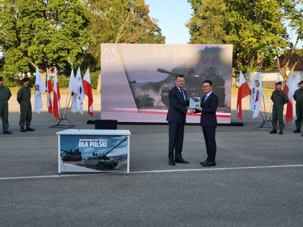 폴란드 모롱크시 소재 기계화부대에서 열린 K9자주포 계약식에서 손재일 한화디펜스 대표이사(오른쪽))가 마리우시 브와슈차크 폴란드 국방부 장관과 악수하고 있다. (사진=한화디펜스)