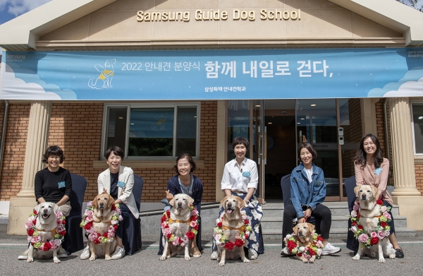 20일 용인 삼성화재안내견학교에서 6년에서 8년간의 안내견 생활을 마치고 반려견으로 새롭게 삶을 시작하는 은퇴견 6마리와 입양가족이 기념 촬영을 하고 있다. (사진=삼성)