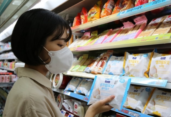 GS리테일의 편의점 GS25에서 한 모델이 생크림도넛 솔티밀크 제품을 들고 있다. (사진=GS리테일)