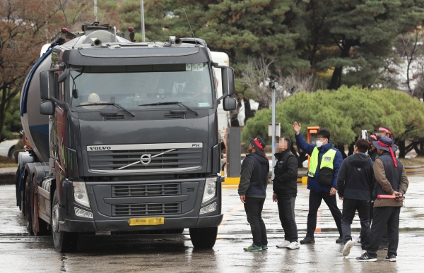 화물연대 충북지부 조합원들이 29일 성신양회 단양공장 정문 앞에서 비조합원 화물차량을 막아서고 파업에 동참해달라고 설득하고 있다. (사진=연합뉴스)