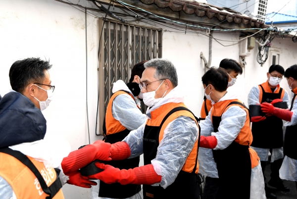 한두희 한화투자증권 대표이사(가운데)와 임직원들이 연탄을 나르고 있다. (사진=한화투자증권)