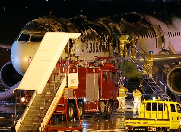 28일 오후 김해공항 계류장에서 승객 170명과 승무원 6명을 태우고 이륙을 준비하던 홍콩행 에어부산 항공기 BX391편 내부에서 불이 나 소방대원들이 진화 작업을 하고 있다. 화재는 1시간 16분 만에 완전히 진압됐고 승객 170명(탑승 정비사 1명 포함), 승무원 6명 등 모두 176명은 비상 슬라이드로 모두 탈출했다. 2025.1.29handbrother@yna.co.kr