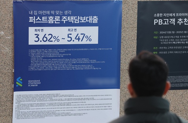 서울 시내 한 은행에 부착돼 있는 주택담보대출 안내광고를 시민이 보고 있다. (사진=연합뉴스)