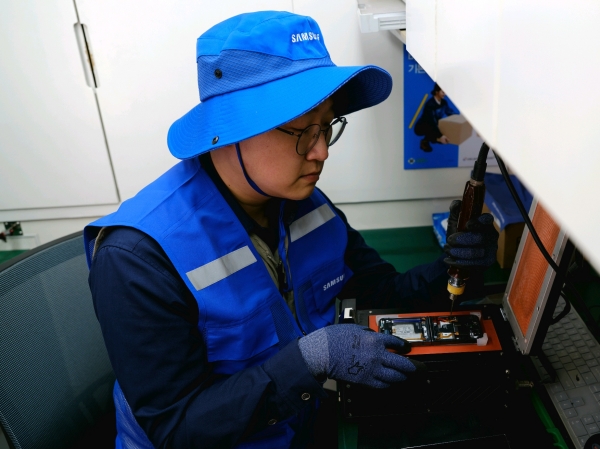 삼성전자서비스 재난복구특별서비스팀 직원이 지난 3월 28일 경북 의성 실내체육관에 마련된 이재민 대피소에서 산불 피해 주민의 휴대전화를 무상 수리하고 있다. (사진=삼성전자서비스)