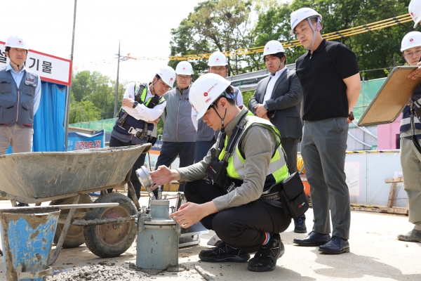 롯데건설 직원이 '차세대 혼화제'가 적용된 콘크리트를 테스트하고 있다(사진=롯데건설)