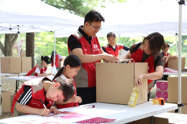 롯데건설 샤롯데 봉사단이 국가유공자 보훈가정을 위한 응원카드를 작성하고 기부물품을 포장하고 있다 (사진=롯데건설)