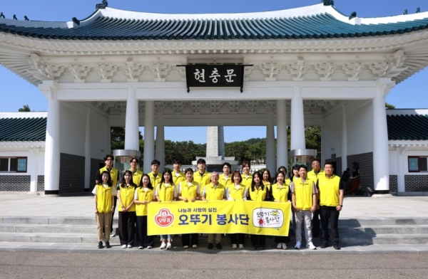 지난 6월 11일 오뚜기 봉사단이 현충문 앞에서 기념촬영을 하고 있다. (사진=오뚜기)