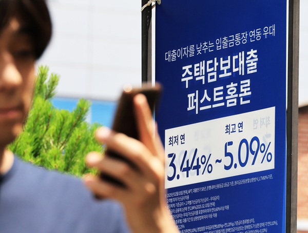 한 시민이 서울 시내 은행 대출 홍보물 앞을 지나가고 있다. (사진=연합뉴스)