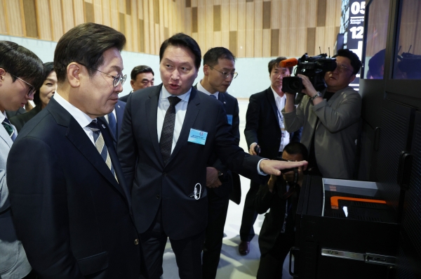 이재명 대통령이 20일 울산전시컨벤션센터에서 열린 인공지능(AI) 글로벌 협력 기업 간담회 뒤 AI 제품·서비스 시연을 참관하며 최태원 SK그룹 회장의 설명을 듣고 있다. (사진=연합뉴스/대통령실통신사진기자단)