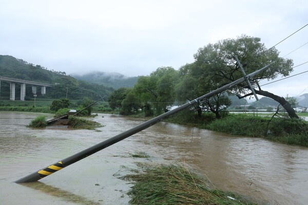 17일 오후 호우특보가 내려진 충남 공주시 사곡면에서 한 도로가 무너져 내렸고 전봇대가 위태롭게 쓰러져 있다. (사진=연합뉴스)