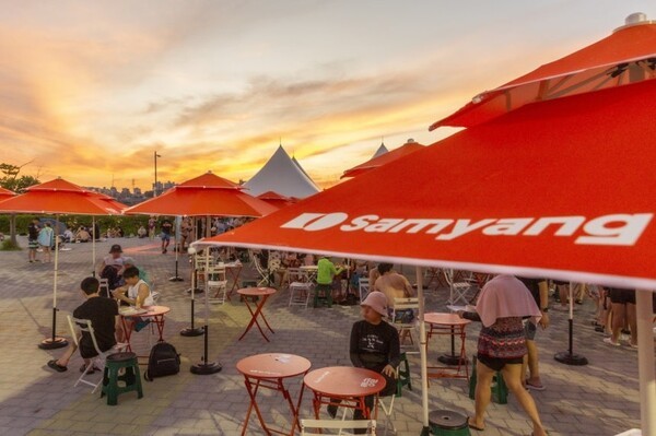 한강공원 수영장 푸드존에 마련된 삼양식품 파라솔 아래에서 시민들이 물놀이 후 여유로운 시간을 보내고 있다. (사진=삼양식품)