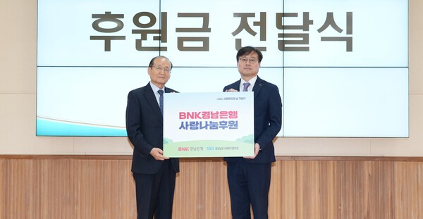 BNK경남은행 최대식 부장(사진 오른쪽)이 제26회 사회복지의 날 기념식에 참석해 경상남도사회복지협의회 박성욱 회장에게 사랑나눔후원 증서를 전달하고 있다. (사진=BNK경남은행)