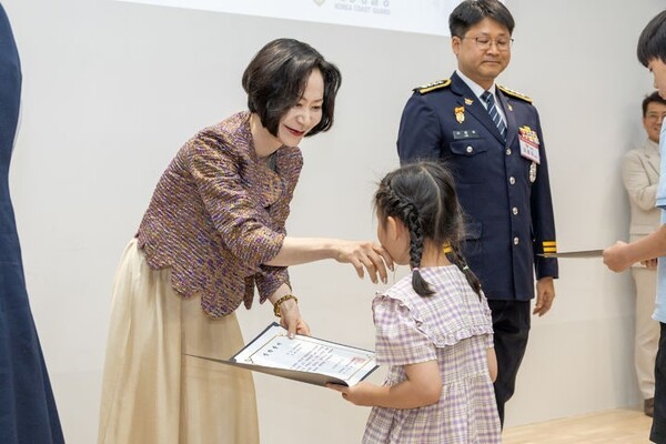 롯데장학재단 장혜선 이사장이 장학생에게 장학증서를 수여하며 인사를 나누고 있다. (사진=롯데장학재단)