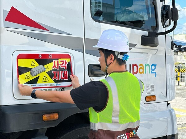 쿠팡·쿠팡로지스틱스서비스 대형 화물차에 '사각지대 주의' 알림 표지를 부착하는 모습 (사진=쿠팡)